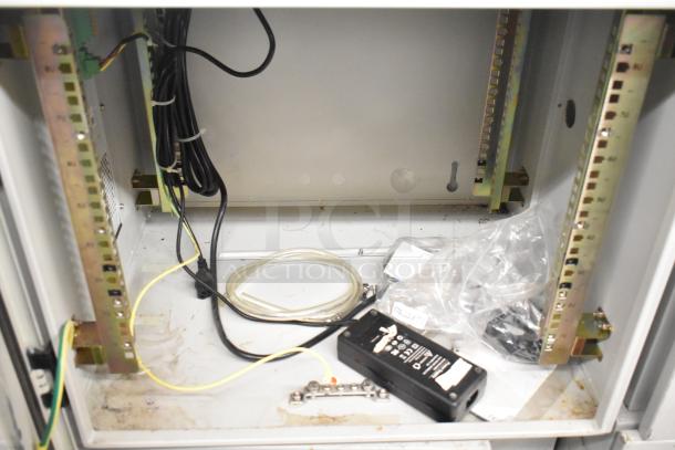 Two BlackShields DC0300 white metal cabinets, interior view, showing wiring and components.