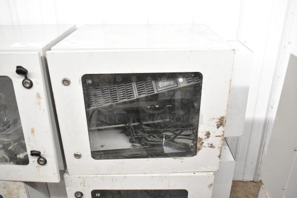 Two BlackShields DC0300 white metal cabinets with glass fronts, showing signs of wear and visible internal wiring.