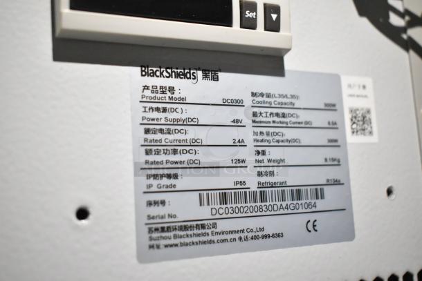 2 BlackShields DC0300 white metal cabinets. Features cooling system, IP55 rating. Model label details technical specs.