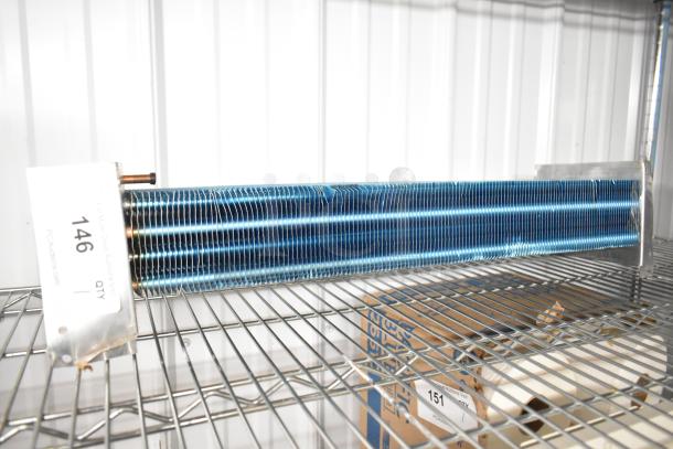 Brand new evaporator coil, blue fins, visible minor scratches and dents, metal casing, tag showing "146" quantity "1".