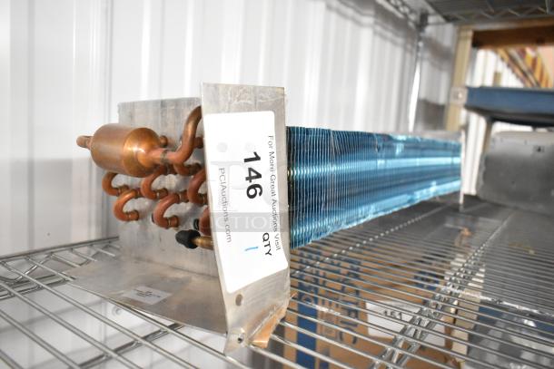 BRAND NEW SCRATCH AND DENT evaporator coil with copper tubing, metal fins, auction tag labeled “146” showing.