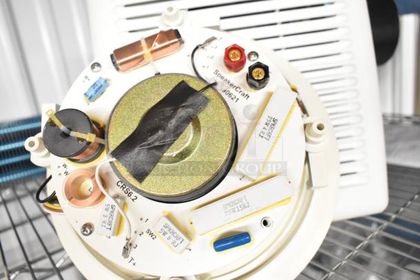 SpeakerCraft indoor speaker components, model CRS6.2, with visible wiring and labels. Ventilation fan unit shown in background.