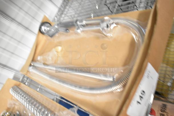 Brand new faucet with spray nozzle attachment, scratch and dent condition, in original packaging on warehouse shelf.