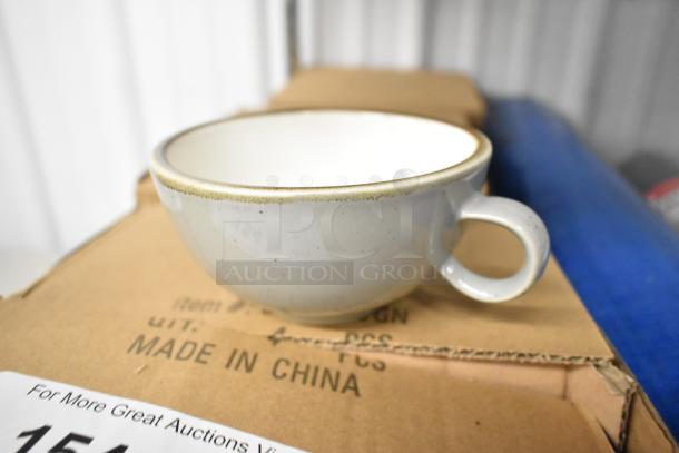 Brand new ceramic mug on top of a box marked "Made in China." The mug has a simple design with a light grey color and handle.