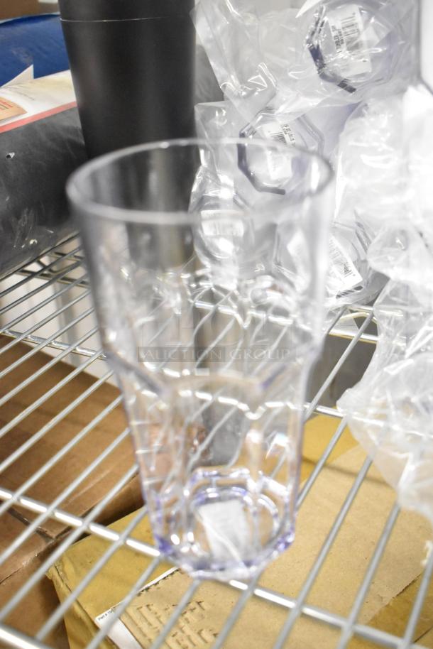 12 various items including beverage glasses and metal mixing cups on a shelf. Items are new in plastic packaging.