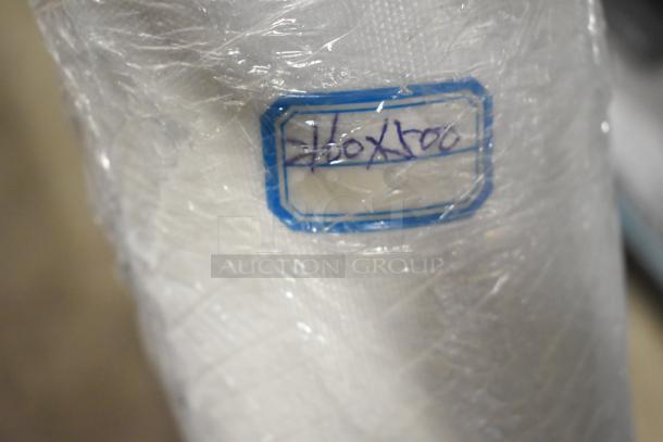 San Jamar poly topping rail, black stand, and roll of material with blue tag reading "40x100"; plastic wrap visible.