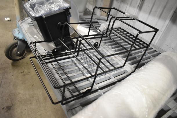 3 various items including San Jamar poly topping rail, black stand, and roll of material, on metal shelf.