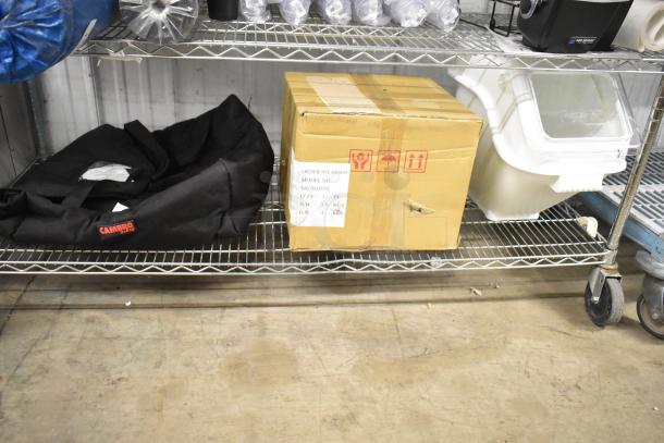 Three items on a metal shelf: a Cambro black insulated food bag, a white poly ingredient bin with lid, and a Hobart HMM20 mixing bowl in a box.