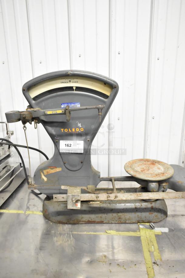 Toledo 3420 countertop metal bakery scale, vintage condition, visible wear and rust, branded markings on display.