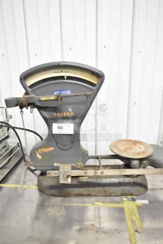 Toledo 3420 countertop metal bakery scale, vintage condition, visible wear and rust, branded markings on display.