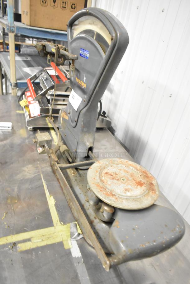 Toledo 3420 countertop metal bakery scale, vintage design, visible wear and rust, dual-pan balance, clear Toledo branding.