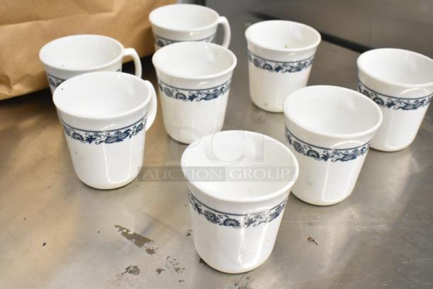 Eight white ceramic mugs with blue floral design, gently used, perfect for everyday use or collection.