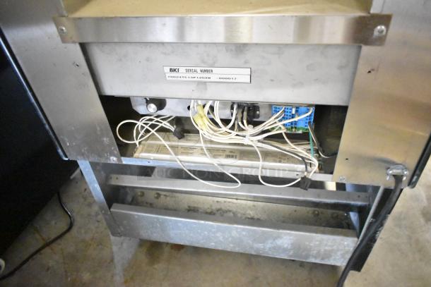 BKI HSS2-4T metal commercial reach-in hot merchandiser with visible wiring and serial number plate, on casters.