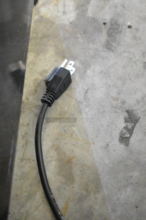 Power cord of KoolMore KM-MDF-17S Metal Freezer Merchandiser on a concrete floor. Plug type visible.
