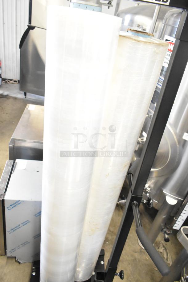 Fantom Full Web Manual Stretch Wrapper, features large stretch film rolls, black frame, excellent condition, ideal for packaging.