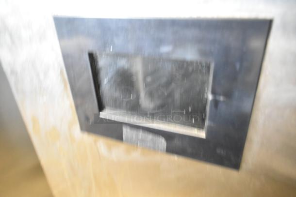 Blurred close-up of Automatic Bar Controls JT-NITCOM-R cold brew nitro dispenser with a stainless steel panel.