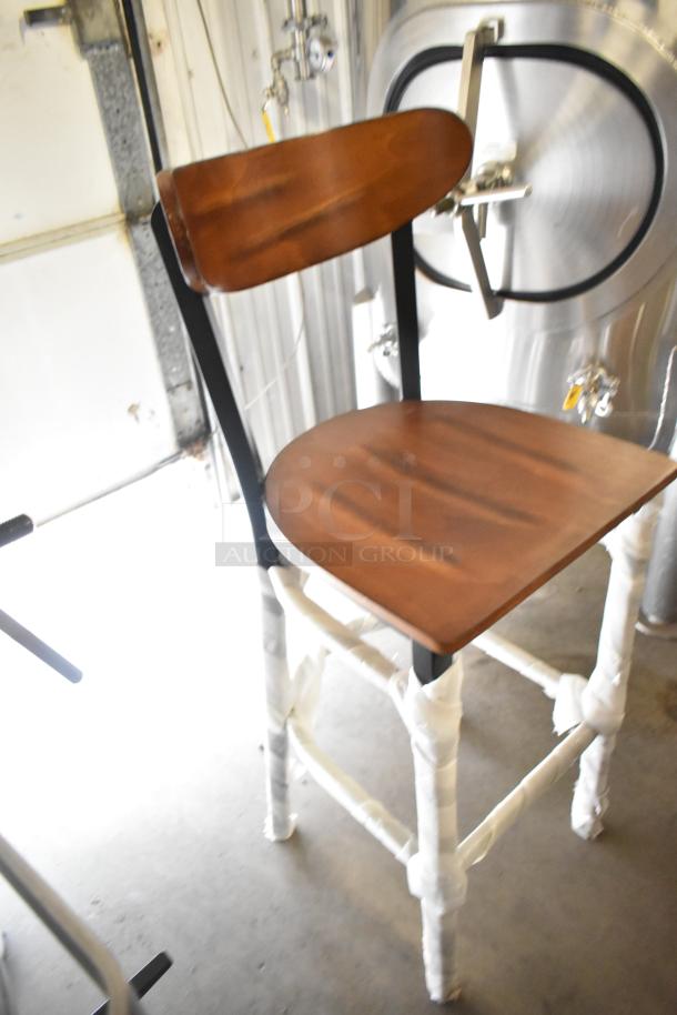 Wooden bar height chair on black metal frame, new with slight scratches and dents, factory wrapping visible on legs.