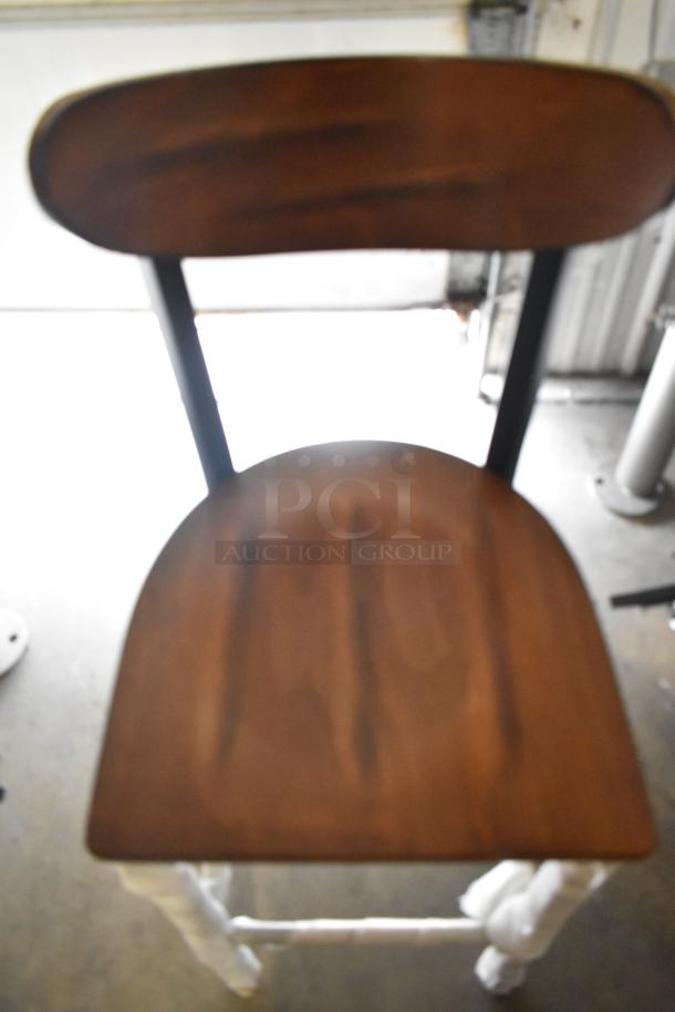 Bar height chair with wooden seat and black metal frame, new condition with minor scratches and dents.