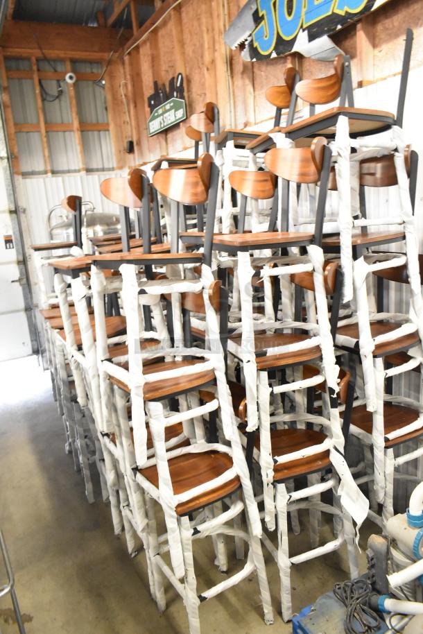 54 brand new wooden bar height chairs with black metal frames, wrapped for protection, scratch and dent condition.