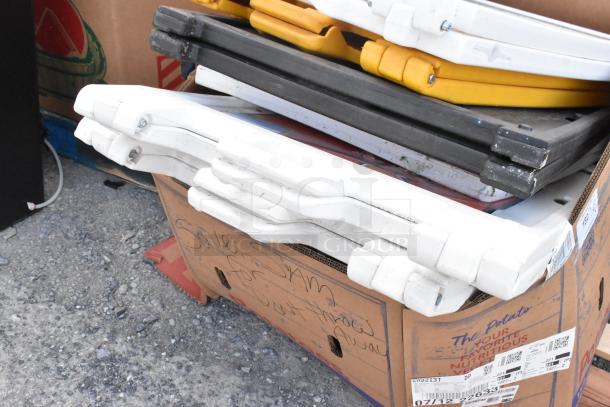 6 sidewalk A-frame signs stacked on cardboard, varying colors, used condition, suitable for advertising.