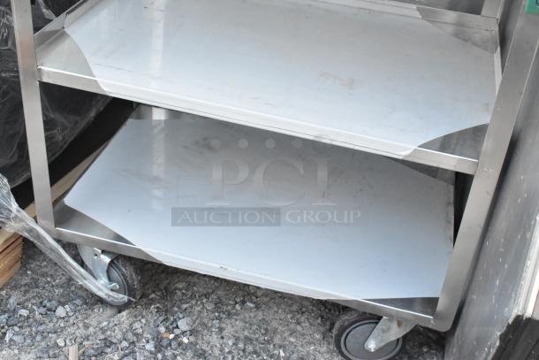 Brand new Regency 600CT1931WD utility cart, three 18-gauge stainless steel shelves, minor scratches and dents visible.