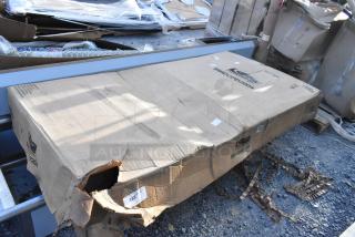 Damaged box containing Suncast BMCCPD7204 dark gray 5-shelf heavy-duty tall storage cabinet, brand new, some dents visible.