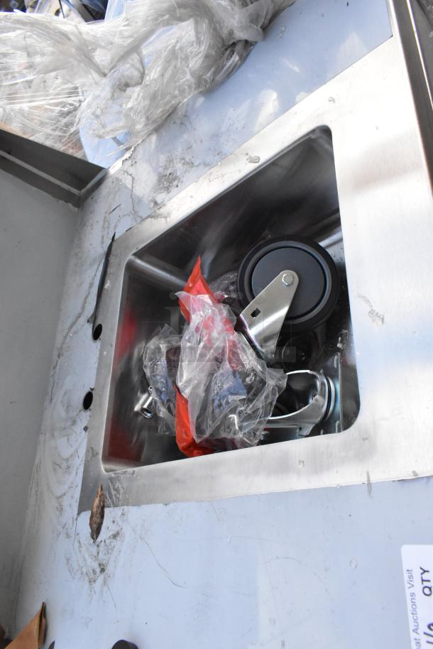 Regency 600PHS30HC portable hand sink cart, single bowl, hot and cold, new with dents, visible wheel and packaging in sink.