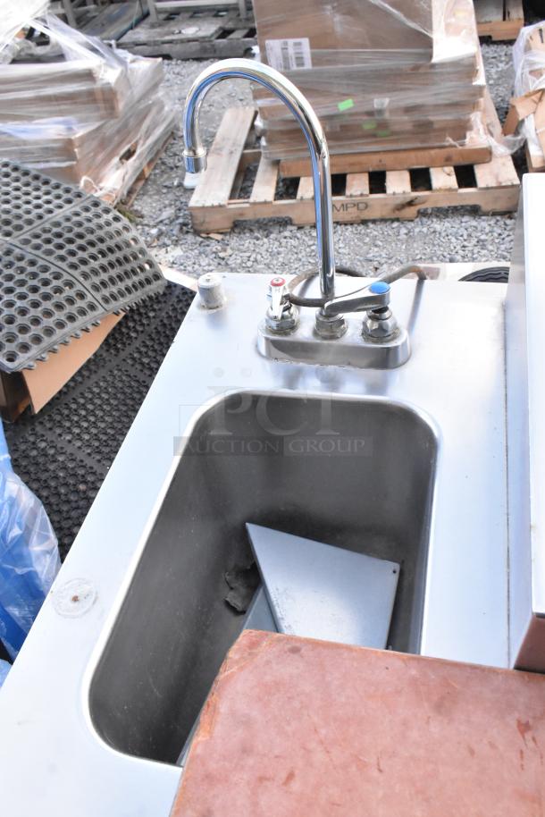 Stainless steel commercial pizza prep table with built-in sink bay, 115 volts, 1 phase, showing faucet and sink.