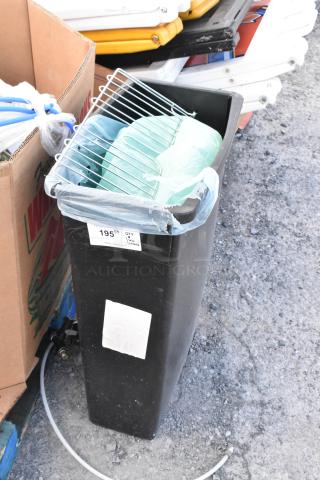 Black Poly Slim Jim trash can with contents, visible label "195 1/4," metal rack on top, general used condition.