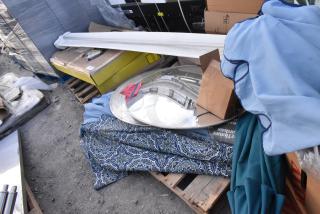 12-item auction lot including patio umbrellas and mirrors on pallets with original packaging; varied conditions.