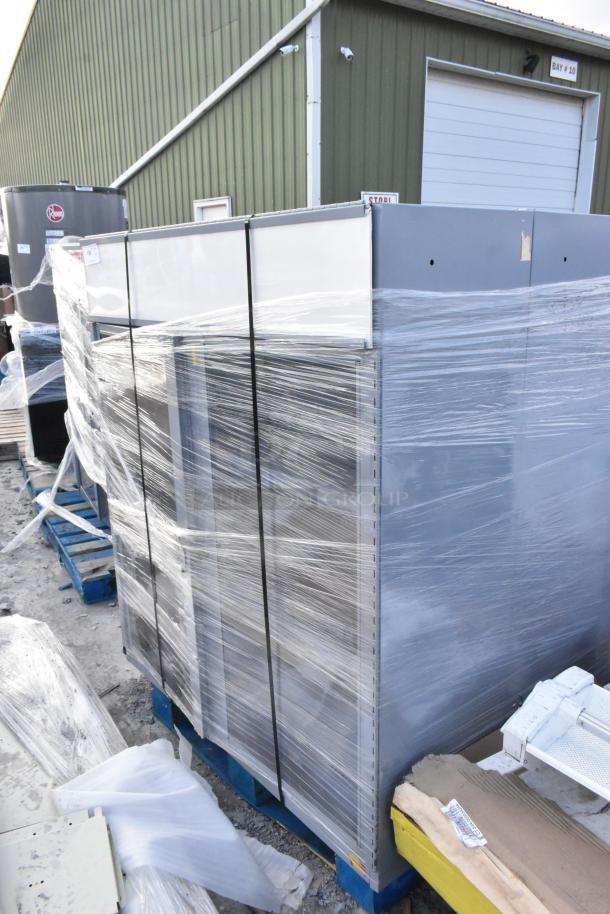 Three gray metal cabinets wrapped in plastic, stored on pallets. Excellent condition, ready for industrial use.
