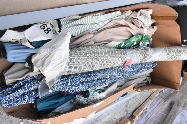 Box of 16 assorted patio umbrellas with various designs and colors, some with tags and labels. Condition appears mixed.