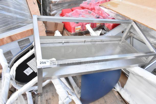 Metal frame shelf unit with label "208" indicating scratch and dent lot, surrounded by various wrapped and packaged items.