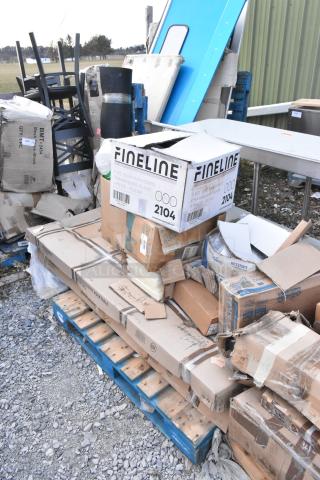 Boxes of scratch and dent items, including work tables and paper towel dispensers, stacked on a pallet. Fineline branding visible.