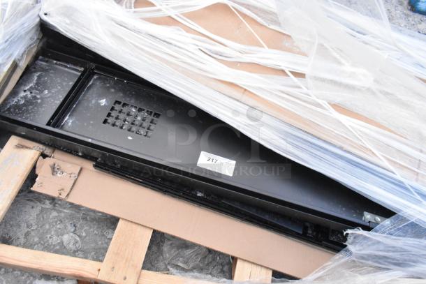 Brand new black metal locker system, scratch and dent, on pallet with partial packaging, visible label with number 217.