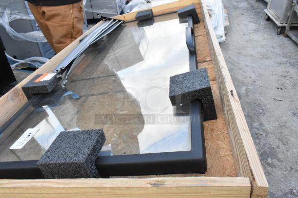 Brand new glass merchandiser door in crate, protective foam corners, and handle visible. Model 29142.