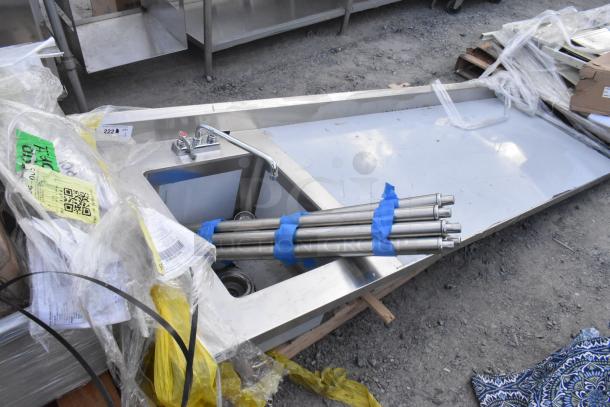 Brand new Regency 600ST3096L stainless steel table, 30x96 inches with 16x20x12 sink, shown with packaging; minor scratches.