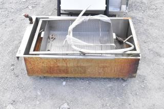 Metal grease trap on commercial casters, features rusted exterior, perforated tray. Used condition, no visible branding.