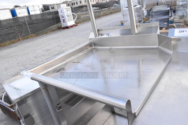 Stainless steel commercial dishwasher table with left side clean area, over and under shelves, in used condition.