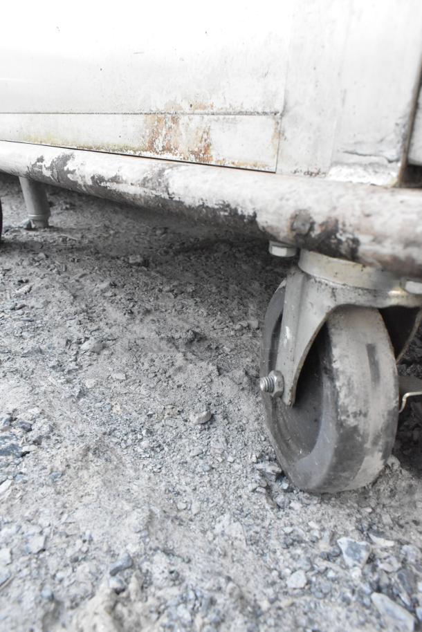 United Metal food carrying case on commercial casters; visible wear and rust, indicating heavy use.