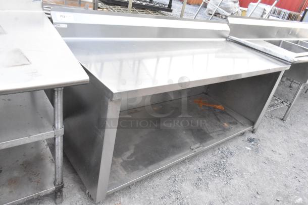 Stainless steel commercial table with under shelf and back splash, in good condition, ideal for kitchen use.