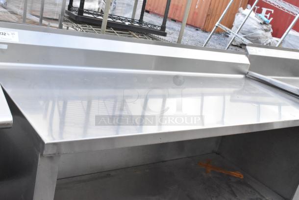 Stainless steel commercial table with under shelf and backsplash. Excellent condition, durable design, ideal for kitchen use.