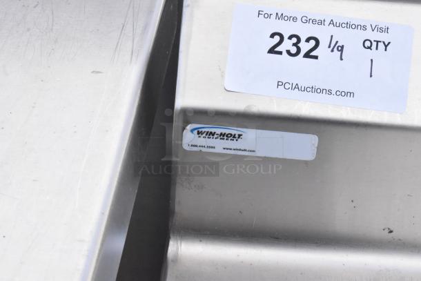 Stainless steel commercial table with under shelf and backsplash, featuring Win-Holt branding and auction label 232/QTY 1.