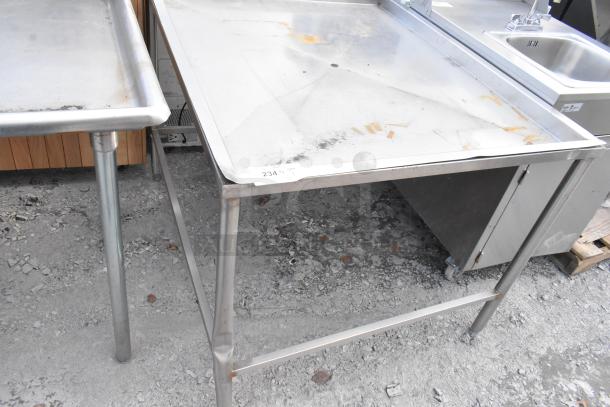 Metal draining table with raised edges and sturdy legs. Visible surface wear and rust. Label reads "234."