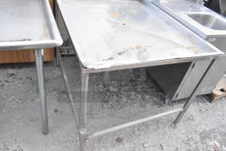 Metal draining table with raised edges and sturdy legs. Visible surface wear and rust. Label reads "234."