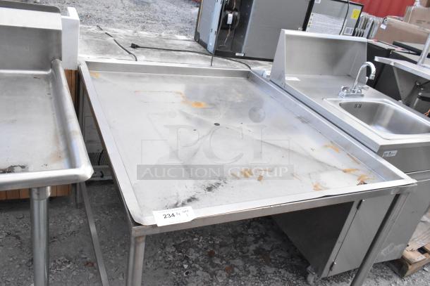 Metal draining table with elevated edges, visible wear and rust. Stainless steel, sturdy with four legs. Auction tag "234 ¼ 9Y".