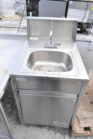 QualServ stainless steel commercial portable sink on casters, with faucet and storage, some visible wear, model tag present.