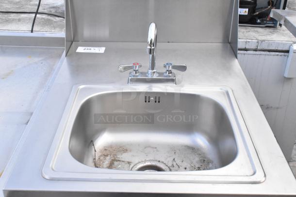 QualServ stainless steel portable sink with faucet, on commercial casters. Slight wear visible in basin. Model 235T.
