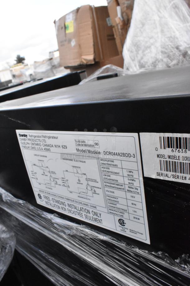Close-up of a Danby model DCR044A2BDD-3 mini cooler label showing specifications and manufacturing details.