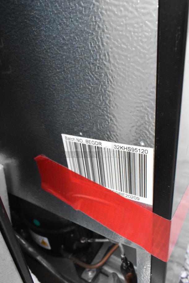 Barcoded label on the back of a mini cooler with red tape. Partial view of cooling components visible below.